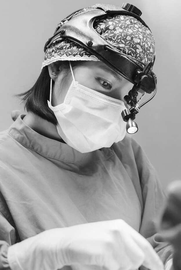 Dr. Yu operating with surgical headlight
